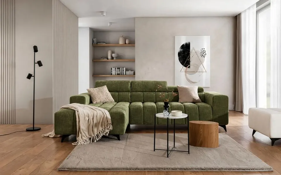 A green GUSTO Mini corner sofa bed styled with cushions and a throw